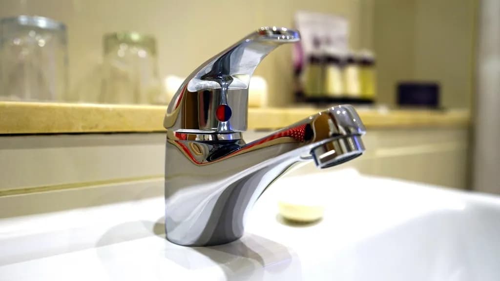 Chrome bathroom faucet on a white basin